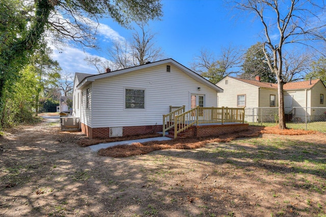 rear view of house featuring fence and a wooden deck