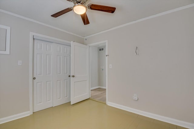 unfurnished bedroom with a closet, visible vents, crown molding, and baseboards