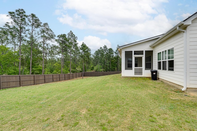 view of yard featuring fence and a sunroom