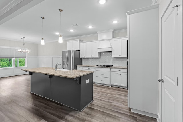 kitchen featuring a sink, a chandelier, stainless steel appliances, visible vents, and white cabinets