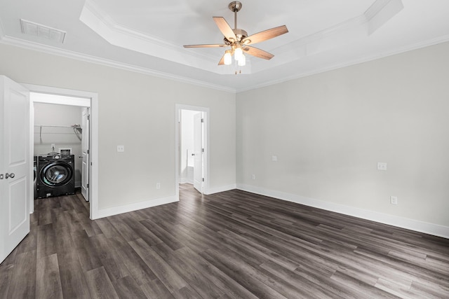 unfurnished bedroom with dark wood-style floors, ornamental molding, and a tray ceiling