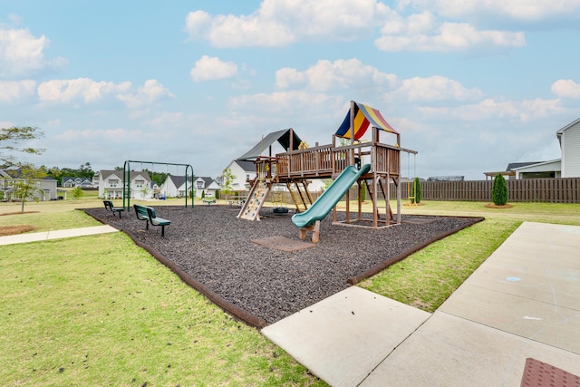 community jungle gym featuring a lawn and fence