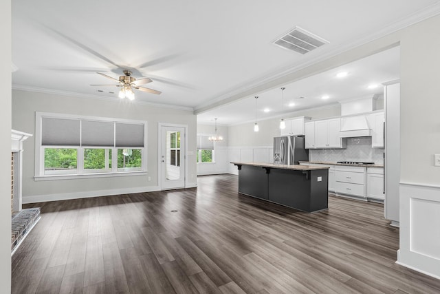 kitchen featuring visible vents, open floor plan, a kitchen bar, stainless steel refrigerator with ice dispenser, and ceiling fan with notable chandelier