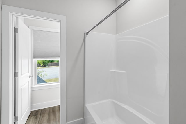 full bath with wood finished floors, shower / bath combination, and baseboards
