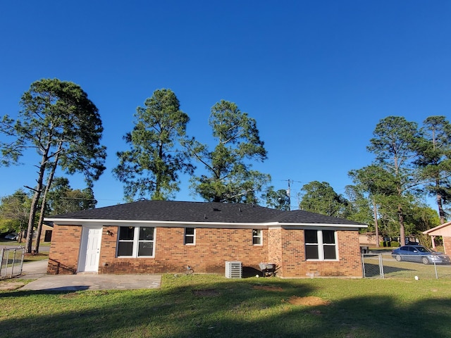 back of property with a yard, a patio area, and central air condition unit