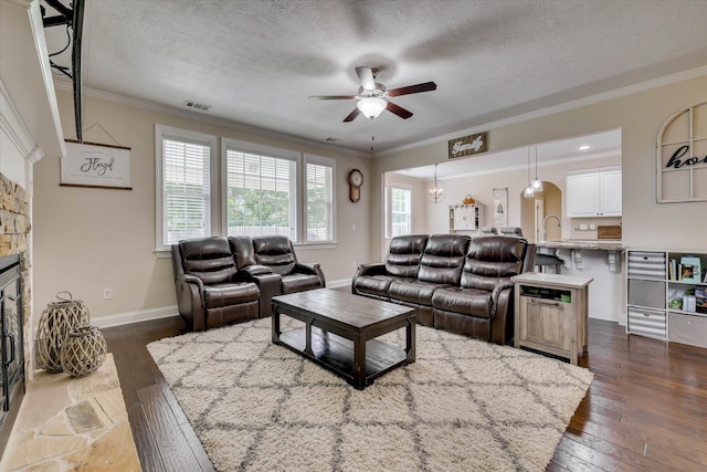 4074 Ellington Dr, Grovetown, GA 30813 - living area with a ceiling fan, dark wood-style floors, ornamental molding, a textured ceiling, and a stone fireplace