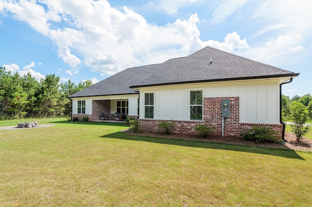 7181 Moontown Rd, Appling, GA 30802 - back of property featuring roof with shingles, brick siding, board and batten siding, a yard, and a fire pit