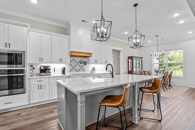 7181 Moontown Rd, Appling, GA 30802 - kitchen with appliances with stainless steel finishes, a chandelier, light wood-type flooring, recessed lighting, and a center island with sink