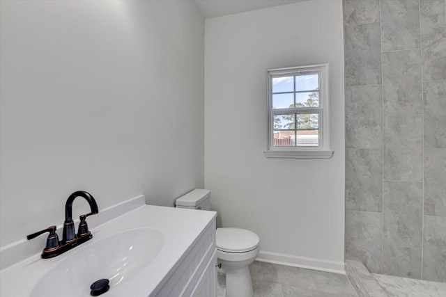 bathroom featuring toilet, vanity, and baseboards