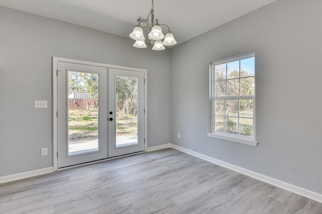 doorway featuring a wealth of natural light, french doors, and baseboards