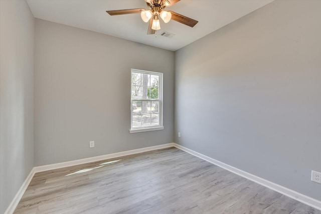 unfurnished room featuring light wood-style floors, baseboards, visible vents, and ceiling fan