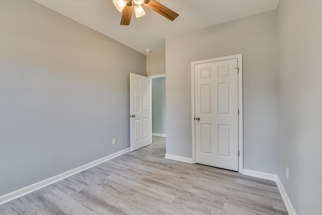 unfurnished bedroom featuring light wood-style floors, ceiling fan, and baseboards