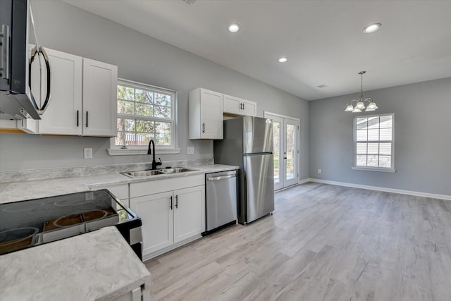 kitchen with a sink, white cabinets, french doors, appliances with stainless steel finishes, and plenty of natural light