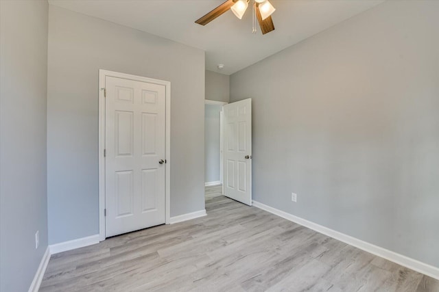 unfurnished bedroom with light wood-style floors, baseboards, and a ceiling fan