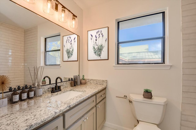 bathroom featuring baseboards, toilet, and vanity