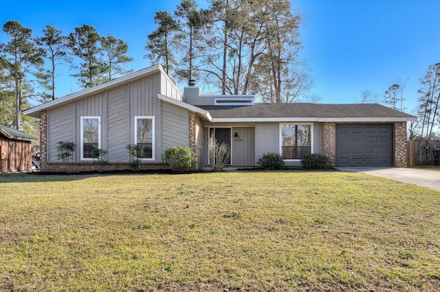 mid-century home with a chimney, a front lawn, concrete driveway, and a garage