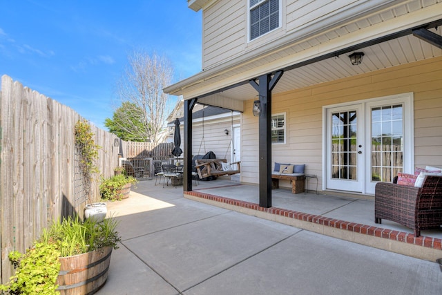 view of patio / terrace featuring outdoor dining area, french doors, and a fenced backyard