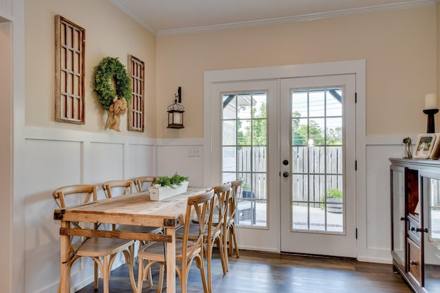 doorway to outside with ornamental molding, a decorative wall, dark wood-type flooring, a wainscoted wall, and french doors