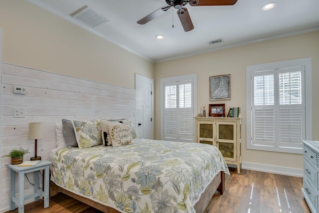 bedroom with crown molding, visible vents, and hardwood / wood-style floors