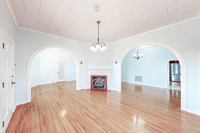 unfurnished living room with ornamental molding and light wood-type flooring