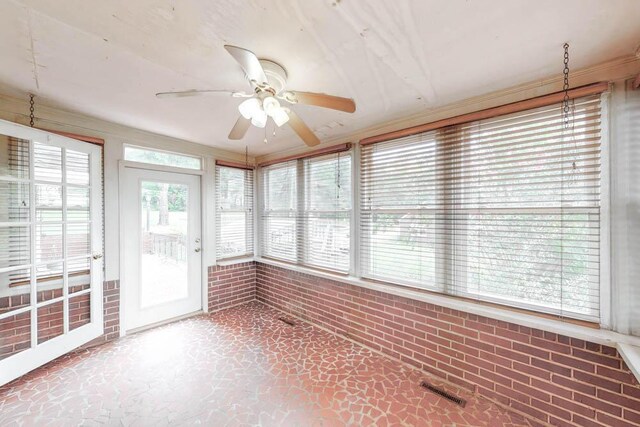 unfurnished sunroom featuring ceiling fan