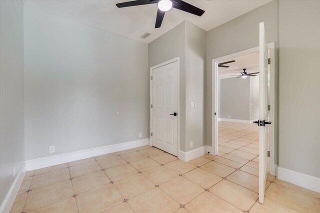 tiled spare room with ceiling fan