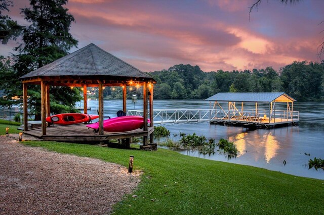 dock area featuring a gazebo, a yard, and a water view