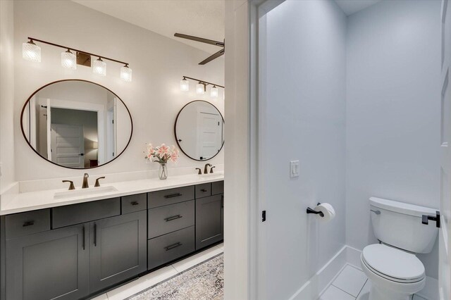 bathroom featuring toilet, vanity, tile patterned floors, and ceiling fan