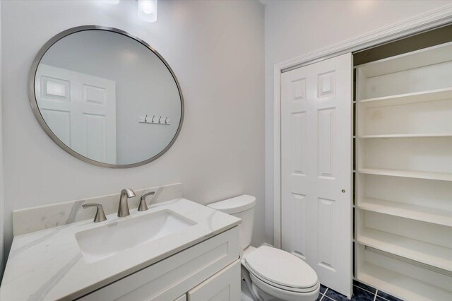 bathroom with tile patterned floors, vanity, and toilet