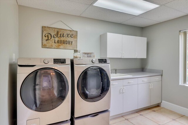 laundry room featuring light tile patterned flooring, cabinets, independent washer and dryer, and sink