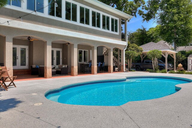 view of pool with a patio area, an outdoor living space, french doors, and ceiling fan