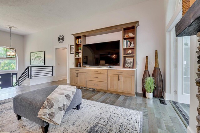 living room with a textured ceiling and dark hardwood / wood-style floors