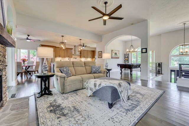 living room with a wealth of natural light, ceiling fan, and pool table