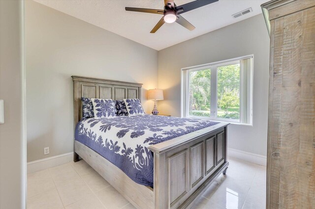 tiled bedroom featuring ceiling fan