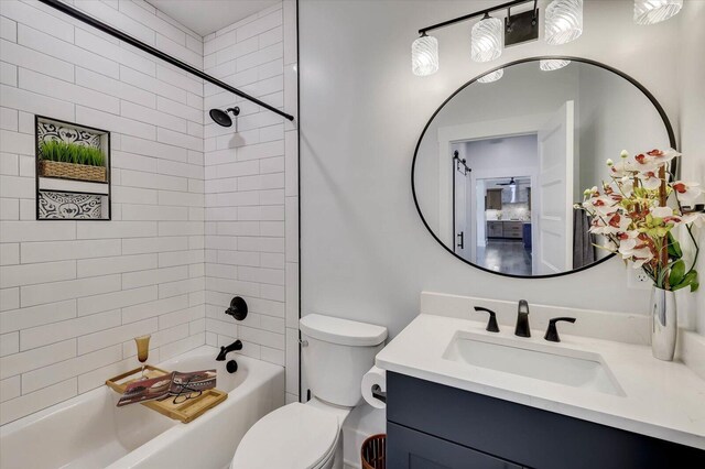 full bathroom with vanity, tiled shower / bath combo, and toilet