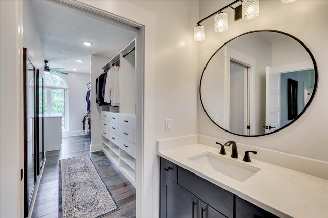 bathroom with hardwood / wood-style floors, vanity, and ceiling fan