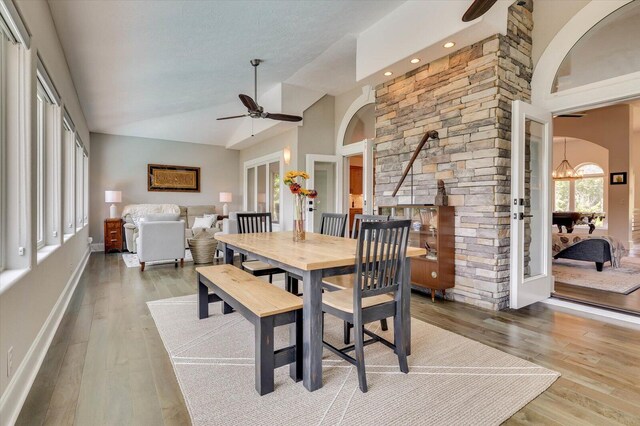 dining area featuring ceiling fan, wood-type flooring, french doors, and vaulted ceiling