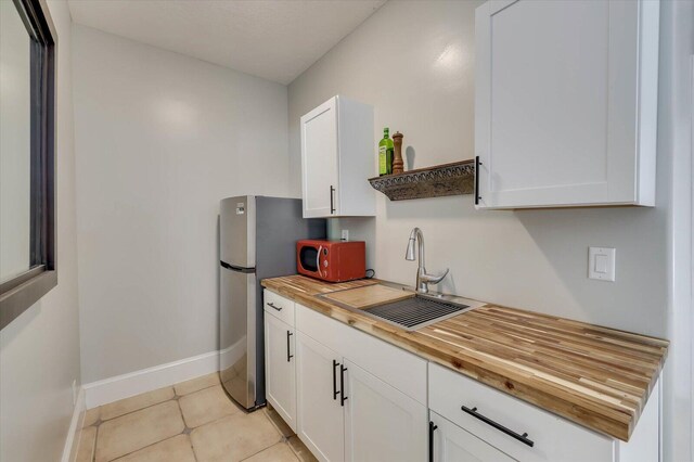 kitchen featuring white cabinetry and butcher block counters