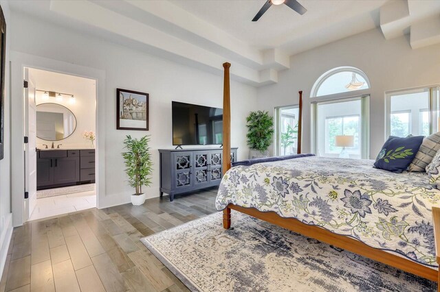 bedroom with hardwood / wood-style floors, ensuite bath, ceiling fan, and sink