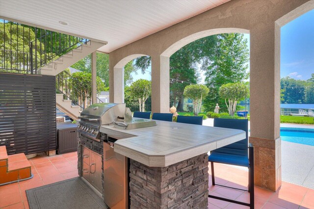 view of patio / terrace with a grill, area for grilling, and an outdoor bar