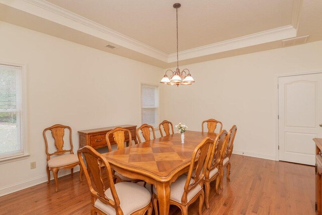 2114 Southlake Pkwy, Augusta, GA 30906 - dining space featuring a tray ceiling, a chandelier, crown molding, and light wood-style floors