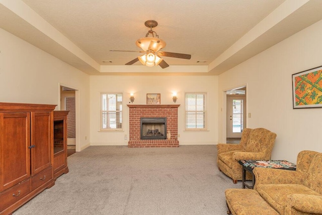 2114 Southlake Pkwy, Augusta, GA 30906 - living area featuring a brick fireplace, a raised ceiling, light colored carpet, and ceiling fan