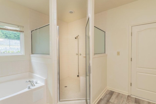 2114 Southlake Pkwy, Augusta, GA 30906 - bathroom featuring a stall shower, a bath, and wood finished floors