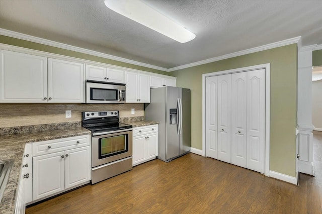 kitchen with white cabinets, ornamental molding, a textured ceiling, and appliances with stainless steel finishes