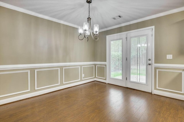 unfurnished room with hardwood / wood-style floors, a notable chandelier, and ornamental molding