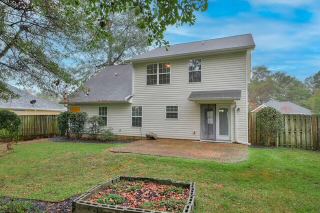 rear view of property with a yard and a patio