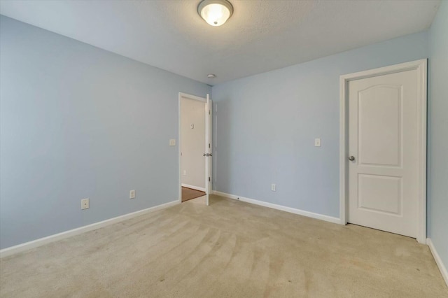 carpeted empty room featuring a textured ceiling