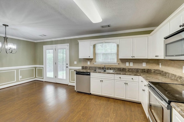 kitchen featuring white cabinets, appliances with stainless steel finishes, pendant lighting, and sink