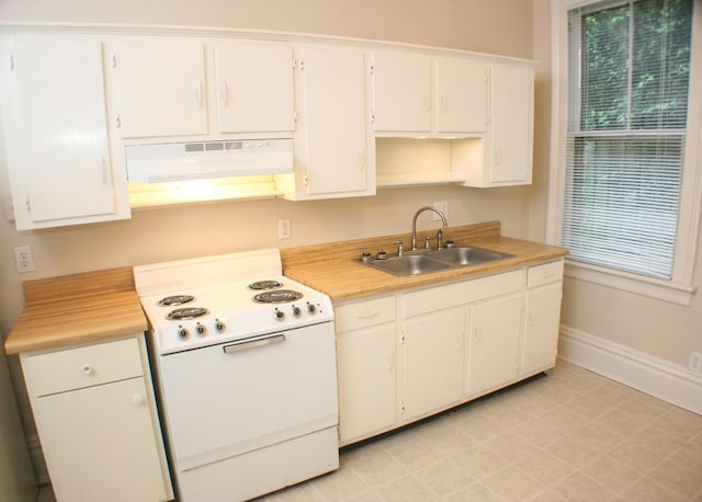 kitchen with under cabinet range hood, light countertops, a sink, electric stove, and baseboards