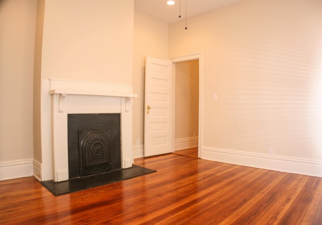unfurnished living room featuring baseboards, recessed lighting, wood finished floors, and a fireplace